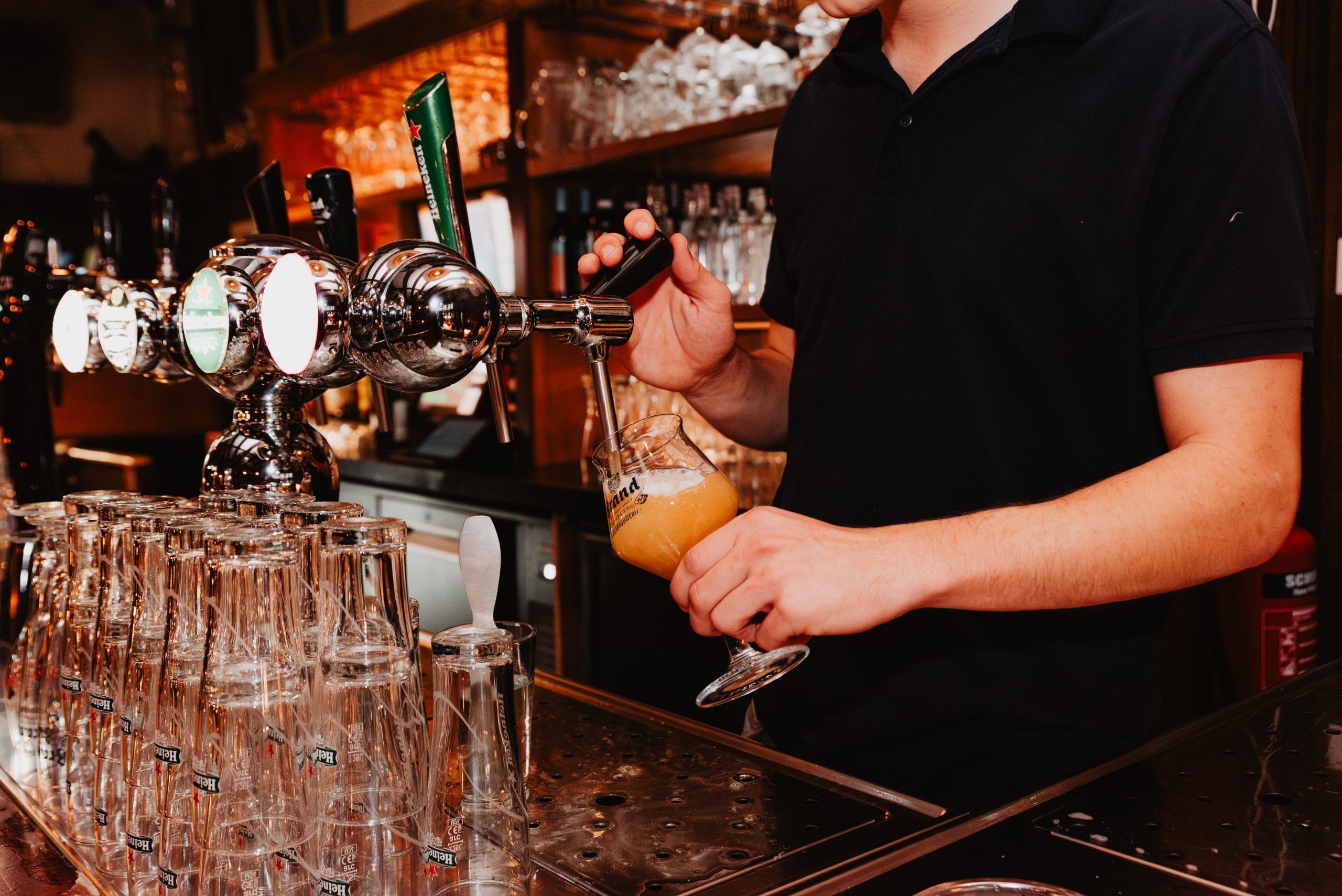 Een medewerker tapt bier achter de bar van Stadtlander